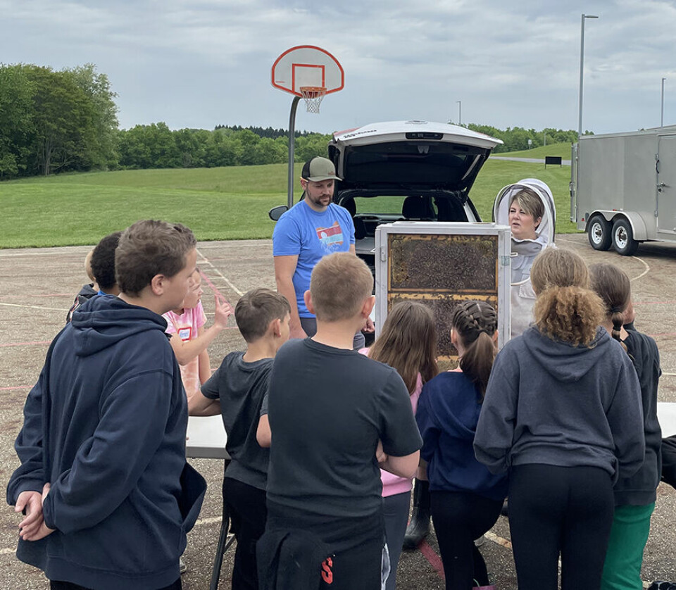 Submitted PhotoAmanda Tubaugh (in beekeeper suit) talks to Carrollton Schools 4th grade students about bees. Seth Halfill, high school science teacher, assisted at the station, which was part of a Field Day for fourth grade students hosted by the Carroll Soil and Water Conservation District.