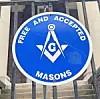 Blue Freemasons sign with the square, compasses and G emblem on a building exterior.