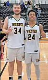 Two Wooster basketball players in white uniforms pose together on an indoor basketball court.