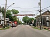 Fire truck and responders on a residential street with houses and a banner overhead.