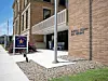 Brick public safety building exterior with entrance canopy, sign, and sidewalk.