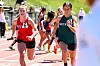 Two female sprinters run side by side on a track during a race.