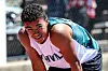 Athlete in teal and white sportswear crouches on an outdoor court.