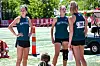 Three athletes in Smithville uniforms stand together outdoors near a track and field area.