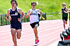 Several runners compete on an outdoor track during a race.