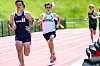 Several runners compete on an outdoor track during a race.
