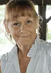 Close-up portrait of a woman looking at the camera indoors.
