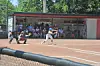 Batter swings at a pitch with catcher and umpire behind home plate during a baseball game.