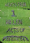 Crowd arranged on a grass field to form the words “NO BULLYING,” “ACTS OF,” and “KINDNESS.”