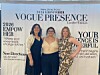 Three women standing together in front of a 2026 Empower Vogue Presence event banner.