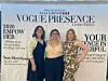 Three women standing together in front of a 2026 Empower Vogue Presence event banner.