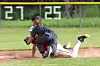 A baseball player slides into a base while a fielder tags him during a game.