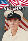 Portrait of a young Navy veteran in a white uniform and cap with an American flag behind him.