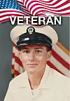 Portrait of a young Navy veteran in a white uniform and cap with an American flag behind him.