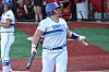 Softball player in a white Danville uniform holding a bat and looking up during a game.