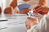 Close-up of hands holding playing cards during a card game at a table.