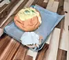 A frosted cake on a tray with a scoop of ice cream on a wooden table.