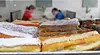 Pastries and cakes arranged on trays in a bakery display case.