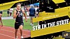 Runner in black crosses a track with a yellow fifth-place graphic overlay.