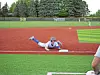 Baseball player sliding headfirst into a base on a field.