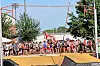 Pole vaulter airborne over the bar at an outdoor track and field meet.