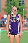 Female athlete in a purple Eastview uniform with a medal and bib stands on a track.