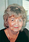 Head-and-shoulders portrait of an older woman indoors near a window.