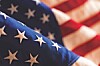 Close-up of American flag fabric showing white stars on blue with red and white stripes behind it.