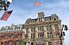 Historic building facade decorated with American flags and bunting beneath a blue sky.
