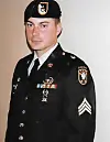 Portrait of a uniformed service member wearing a beret, medals, and shoulder insignia.