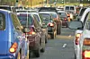 Rows of cars sit in heavy traffic on a city street.