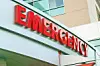 Red emergency sign mounted above a hospital entrance.