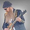 Musician in sunglasses and a patterned hat playing electric guitar.