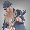Musician in sunglasses and a patterned hat playing electric guitar.