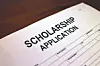 A scholarship application form on a wooden desk.