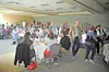 People seated and standing around tables in a large banquet hall.