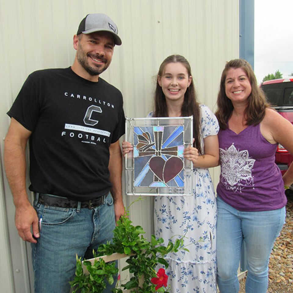 CCM/Thomas ClapperAbigail Zeedyk of Farm Raisers 4-H club sold a handmade stained glass window for $400 to Geno and Heather Kiko, of Kiko Auctioneers and Realty at the July 17 4-H Still Project Auction. Zeedyk cut all of the glass and did the soldering work herself. It has many types of different glass to make up the piece. The cross in the piece is what drew the Kiko family to bid according to Heather Kiko.
