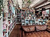 Interior of a bookstore with bookshelves, a display counter, and a brown sofa.