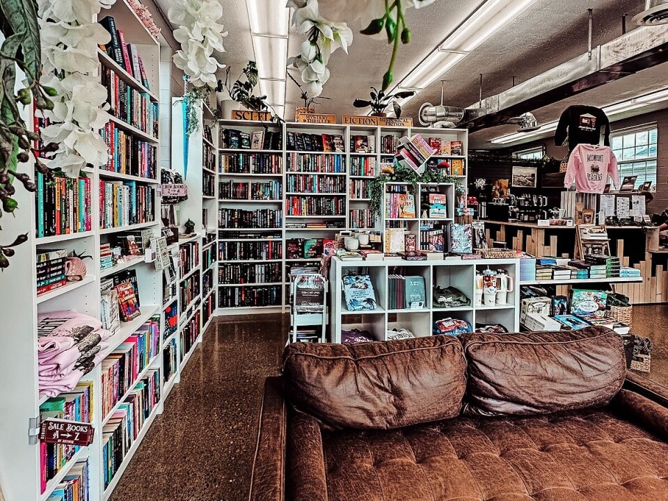 Interior of a bookstore with bookshelves, a display counter, and a brown sofa.