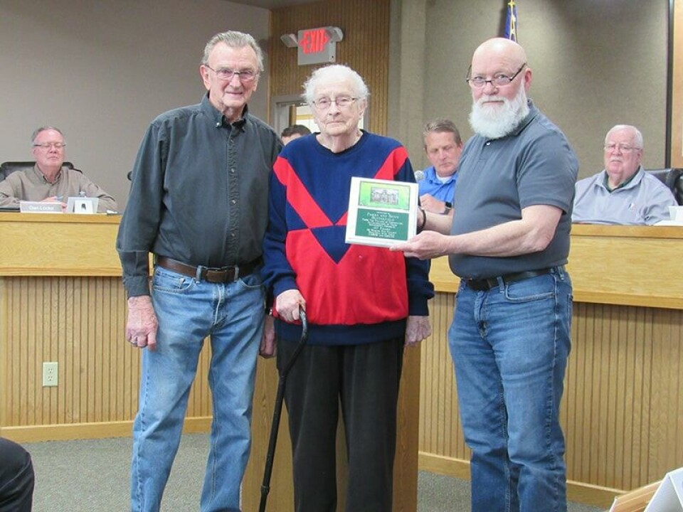 CCM/Thomas ClapperParke (left) and Betty Butterfield are presented a plaque by Carrollton Mayor Bill Stoneman for 40 years of dedicated service to the village as the mowiing crew.