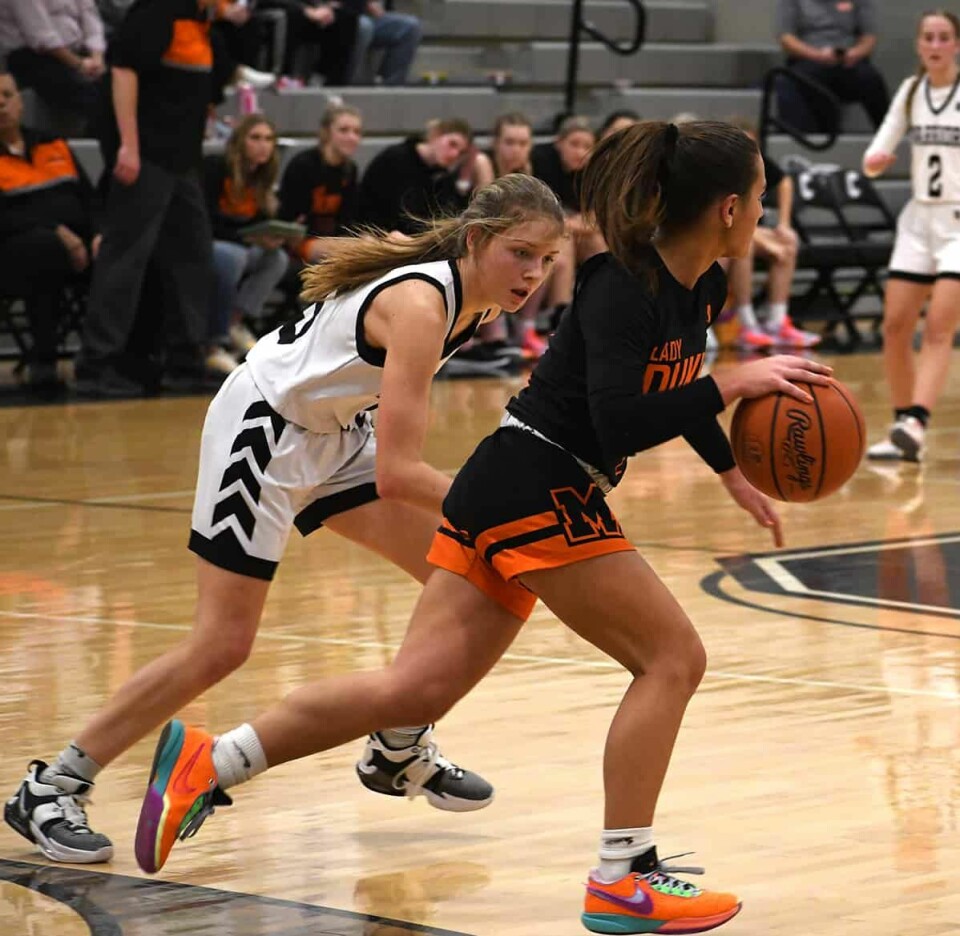 CCM/Dan Ries Carrollton guard Kylie Ujcich (white uniform) keeps pace with Marlington’s Zoe Mart during an Eastern Buckeye Conference contest Jan. 3.