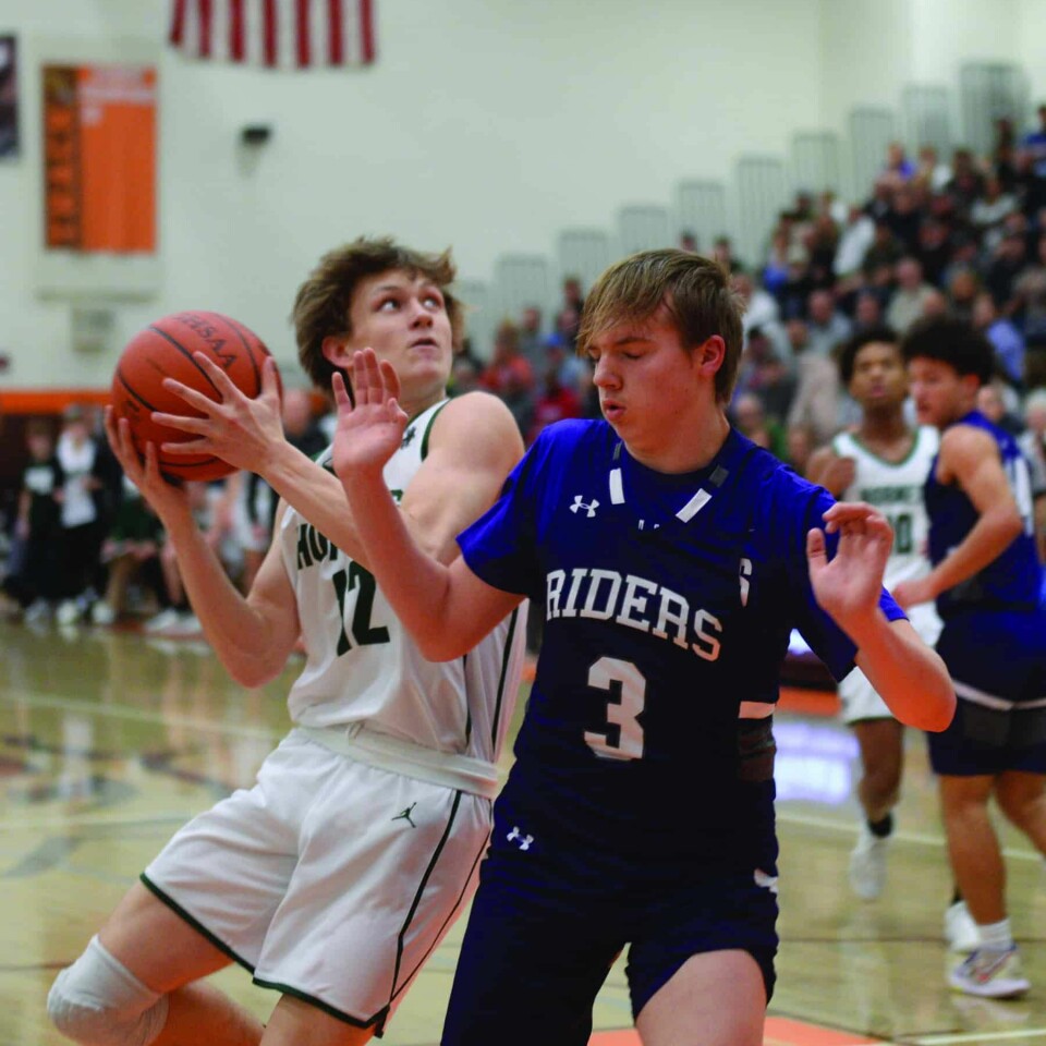 CCM/ Carol McIntireHornet Drake Hutchison (12) drives to the basket against Purple Rider Turner Krol. Hutchison came off the bench to score a team-high 14 points in the win.