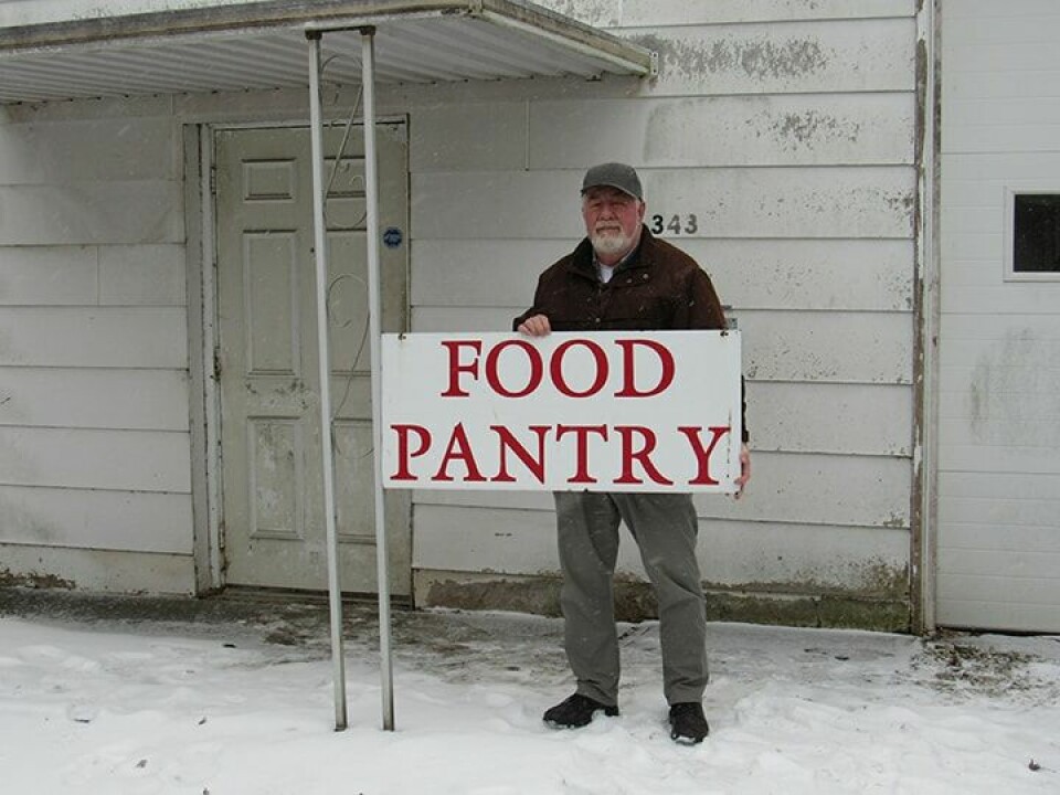 CCM Photo/Thomas ClapperRev. Gordon Warner, Loaves and Fishes Food Pantry director, holds a sign denoting the new home of the food pantry and St.Vincent DePaul in Carrollton.