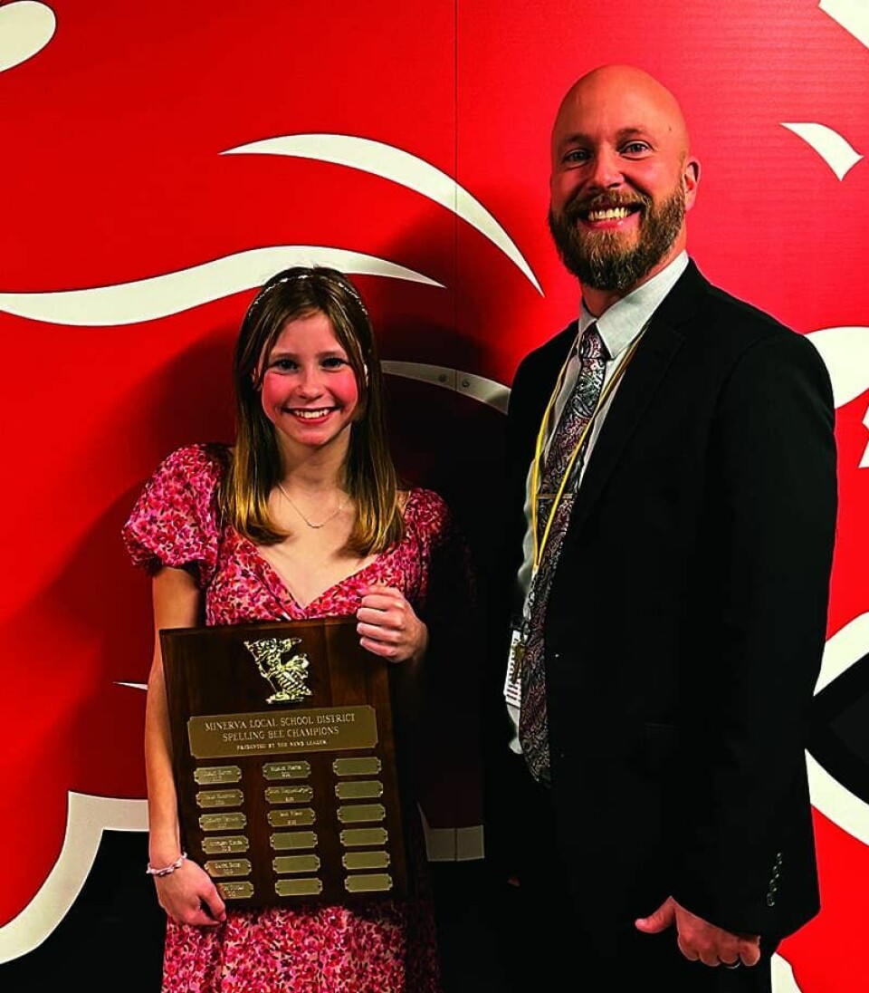 Submitted PhotoMinerva Middle School Principal Josh Morckel presented winner Laney Johnson with the spelling bee plaque.