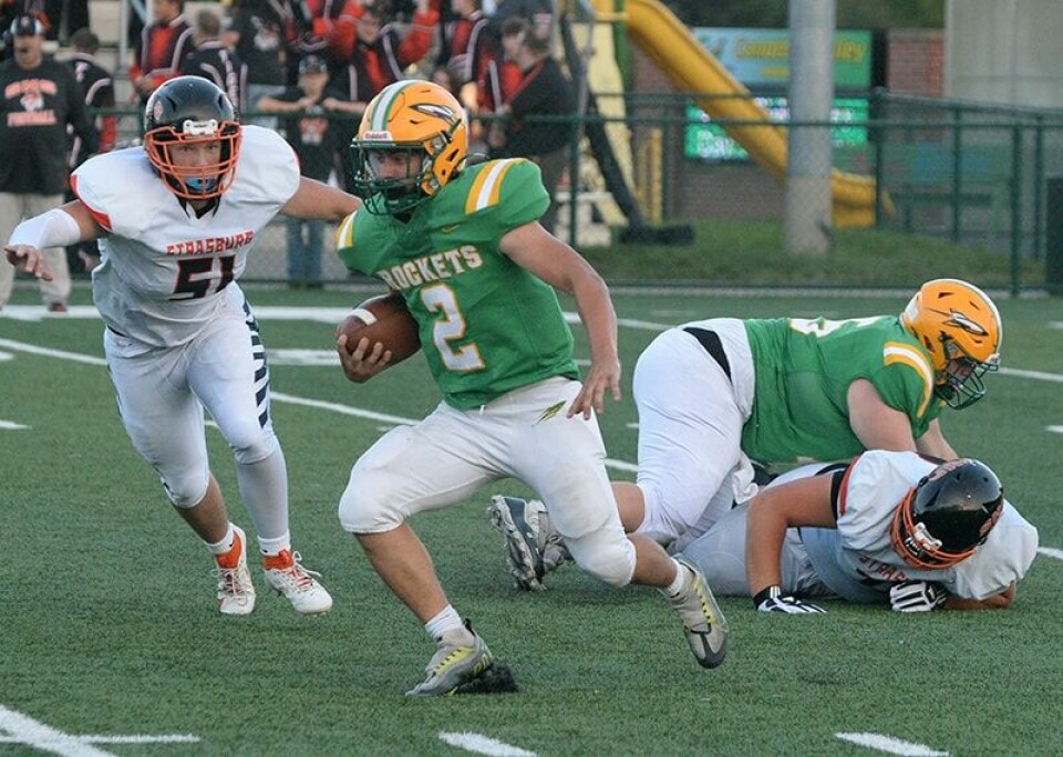 CCM/Carol McIntireRocket running back Noah Smith (2) plants a foot and changes direction to avoid the tackle of Luke Tucker (51) in the first quarter Friday at Conotton Valley.
