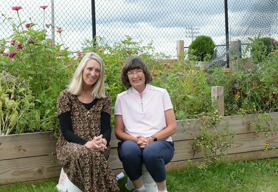 CCM/Carol McIntireBarbara Burns (left) and Kay Russell sit in front of the raised bed gardens near the Carrollton School’s POWER Center. The two are expanding the district’s farm to school initiative,thanks to a Healthy Meals Incentive grant. As part of that program, they plan to grow lettuce and utilize the produce in the cafeteria.