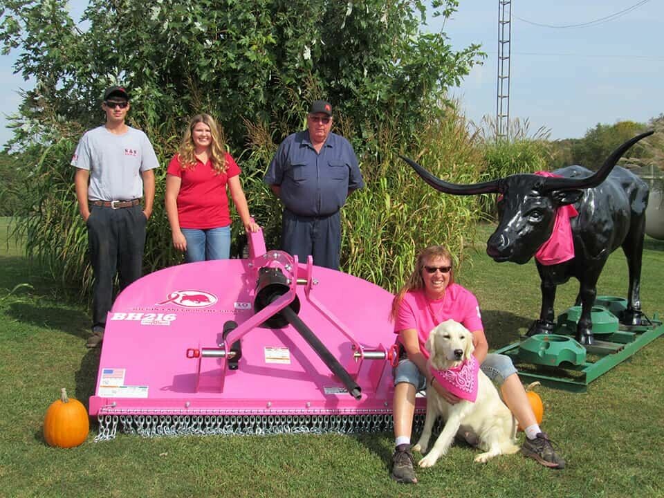 CCM/Thomas ClapperS&S Farm Equipment is raffling off a limited-edition Pink BH216 Cutter by Bush Hog with proceeds going to the American Cancer Society. Pictured from left are Hunter Loy, Shelby Baker, Bud Smith, Maryann Smith and Angel (the dog) and Black Jack The Bull.