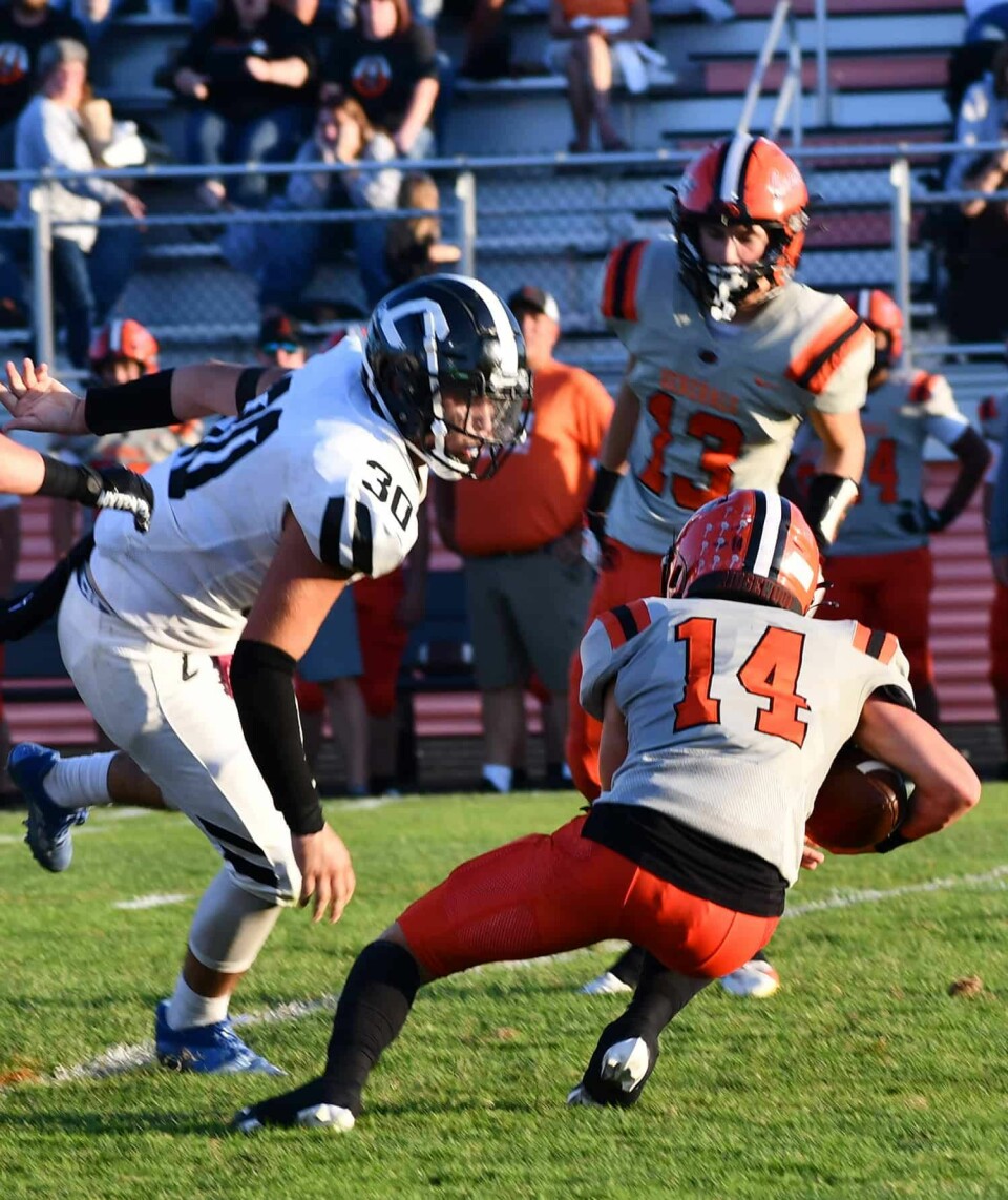 Warrior Nick Lawrence (30) closes in on a tackle of the General's Jake McQueen (14).
