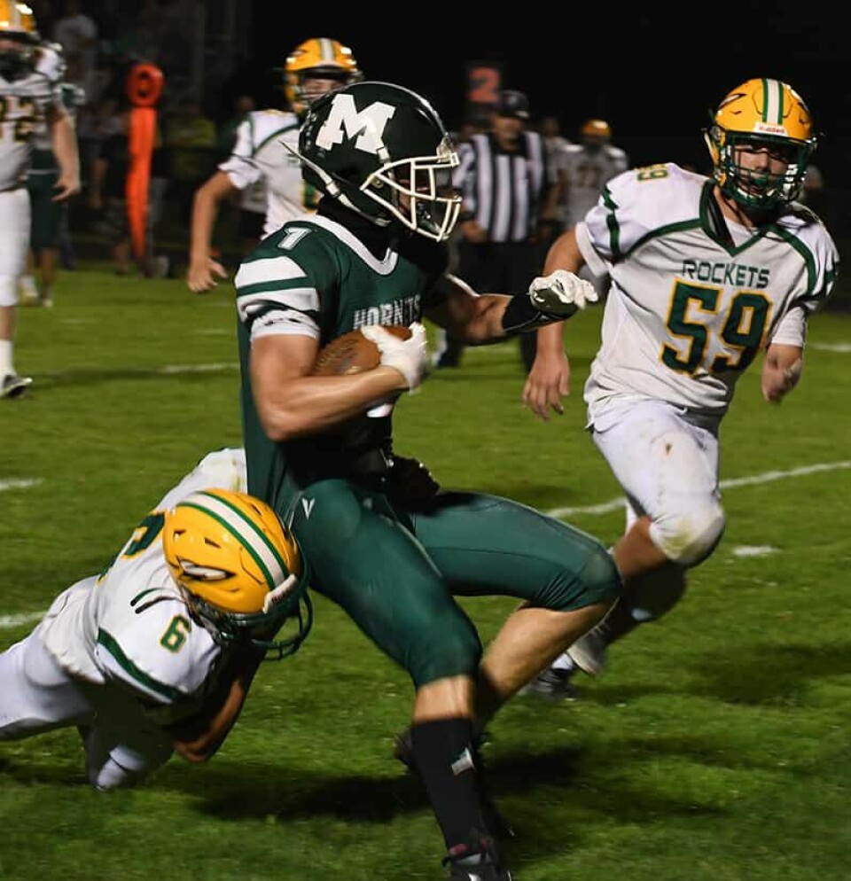 CCM/Dan RiesRocket Luke Smith (6) tackles Hornet Dylan Phillips (1) during a cross-county matchup Friday at Malvern.