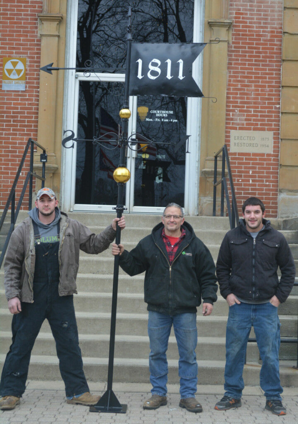 Custom-made weathervane created for courthouse Brad Birkhimer (center) was asked to create a weathervane for the Coshocton County Courthouse. Pictured with him are his sons BJ (left) and Richard (right) who Brad said helped some with the assembly and the design, but were definitely going to help him mount it to the top of the courthouse. Josie Sellers | Beacon
